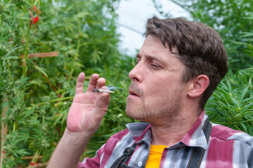 Young person smoking marijuana joint - Cannabis, stoner and weed concept - Main focus on face