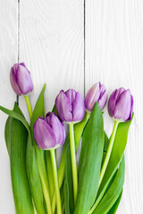 Bouquet of purple tulips, a bouquet of spring flowers on a white wooden background, flat lay.