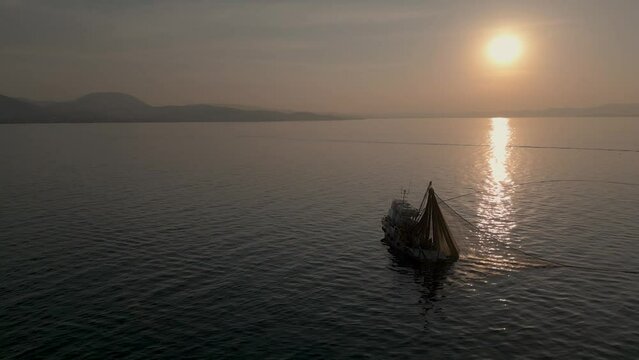 Aerial View of Fishing Ship and Net in Circle Shape, Collecting Fish From sea. Traditional Salmon Fishing in Izmir Turkey, Drone Shot. High quality 4k footage