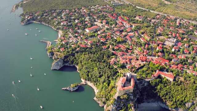 4k drone flying over footage (Ultra High Definition) of Duino Castle. Picturesque morning scene of Adriatic coast of Italy, Europe. Beautiful summer scenery. Traveling concept background..