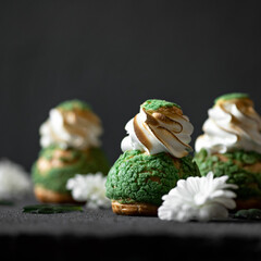Dessert with meringue on table. Decorated with flowers. Close-up. Black background.