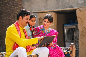 education concept : Indian parents with daughter and holding chalk board.