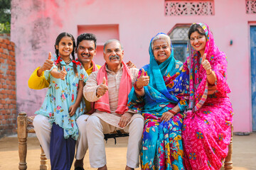 Happy Indian rural family showing thumps up at home.