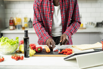 Attractive man cooking in modern kitchen. Handsome chef preparing food.