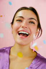 Young woman smiling with confetti
