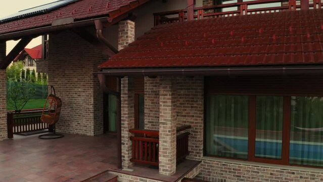 Orbital view of luxury house showing automatic window rolling shutter opening in morning.