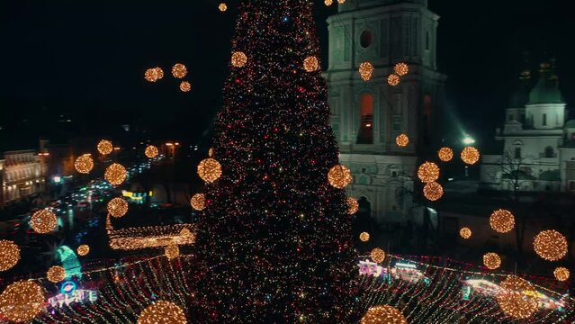 Beautiful Christmas tree during snowfall in the night town. New Year during the snowfall. Christmas or New Year's town. Celebrations. Kyiv 2021. Christmas atmosphere in the night city. 