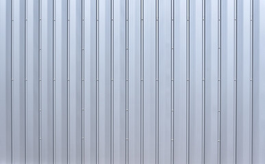 Silberfarbene Aluminium Wandverkleidung mit vertikalen Rillen und mehreren Reihen Sechskantschrauben