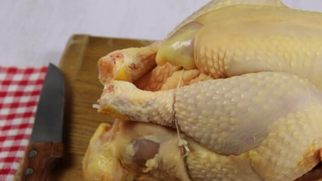 chapon cru, en gros plan, sur une table