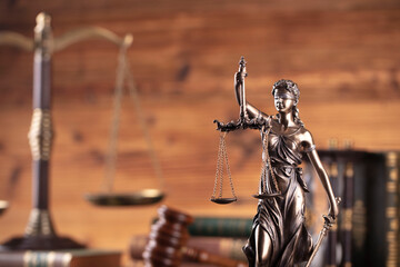 Law symbols composition. Gavel, scale, legal code and Themis sculpture on brown background.