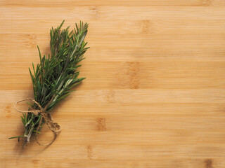 Bunch of rosemary herb on the wooden board background