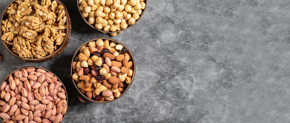 Walnuts, pistachios, hazelnuts and mixed nuts in a bowl on a dark background. Empty space for text. copy space. Top view