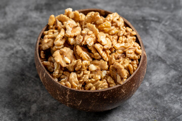 Walnuts in a bowl on a dark background. Walnuts in a coconut bowl. close up