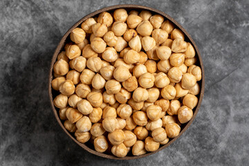 Roasted hazelnuts in bowl on dark background. Nuts in a coconut bowl. Top view