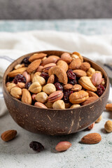 Mixed nuts in bowl on gray background. Nuts, cashews, almonds and pistachios in a coconut bowl. close up