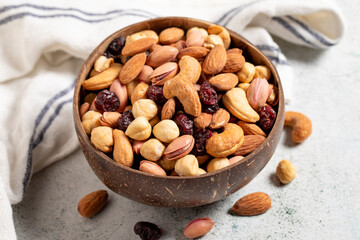 Mixed nuts in bowl on gray background. Nuts, cashews, almonds and pistachios in a coconut bowl. close up