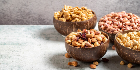 Walnuts, pistachios, hazelnuts and mixed nuts in a bowl on a gray background. Empty space for text. copy space