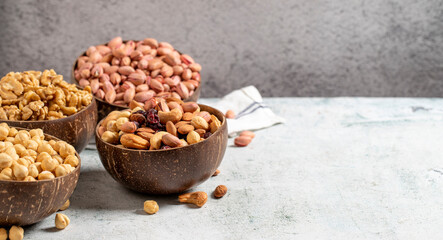 Walnuts, pistachios, hazelnuts and mixed nuts in a bowl on a gray background. Empty space for text. copy space