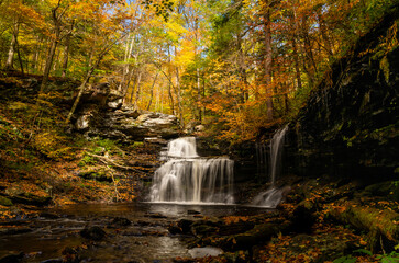 R.B. Ricketts Falls in Ricketts Glen State Park on an Autumn day. The water is smoothed and surrounded by Fall colored trees.