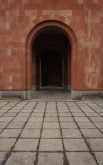 Fototapeta premium elements of architectural decorations of buildings, doors, arch. On the streets, public places. Vintage arcade of the masonry. Wall and facade of the pink tile. tuff material