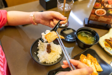 Asian woman's hand holding chopsticks to pick up food
