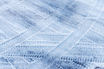 Intersecting traces of tire treads of different cars on a snowy road.