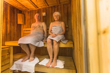 Poster Senior couple relaxes in the spa sauna. High quality photo © PoppyPix