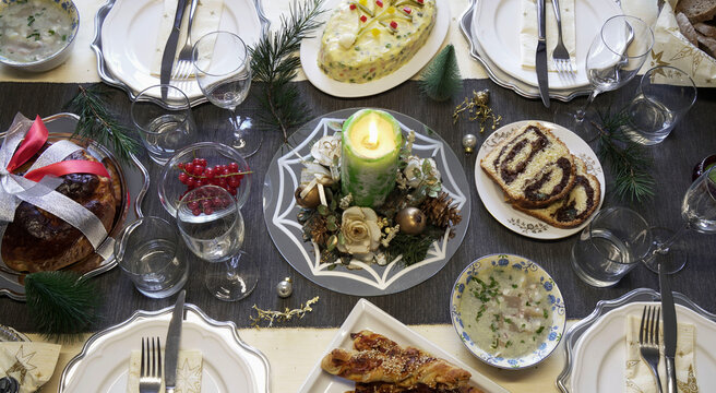 Bella tavola apparecchiata per la cena di Natale o Capodanno con decorazioni natalizie. Concetto di riunione di famiglia. Direttamente sopra.