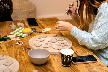 Craftsperson Concept. Young woman making pottery indoors sitting using modeling tool to create pattern.