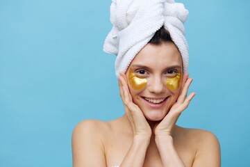  Horizontal photo, a woman with clean skin on a blue background with a towel on her head and body takes care of her face and body in the evenings and relaxes. High quality photo