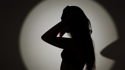 Sexy woman with long hair in red lingerie and stockings posing with bdsm cat mask and whip in studio.Сoncept of role-playing games and bdsm