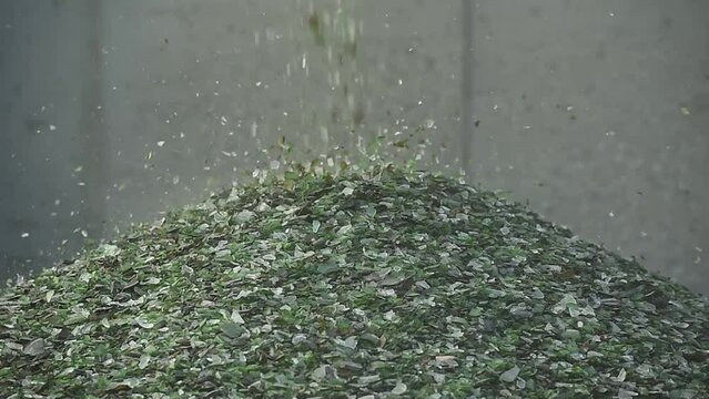 Crushed small pieces of glass are gathered for recycling in a machine in a recycling facility. Glass waste management. Glass recycling