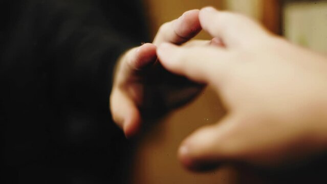 The guy gently reaches out to the mirror and touches its surface. Close-up shooting
