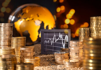 Stock market and economy international. Graphic and stack with money in front of golden globe.