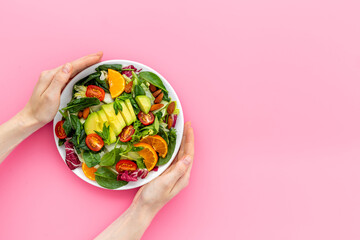 Top view of served green salad with avocado and tomatoes