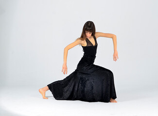 Fototapeta premium Female dancer isolated dancing with black dress on grey background