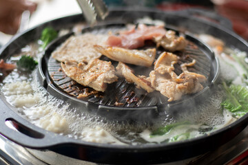 Close-up of roast pork on electric stove. Selective focus.