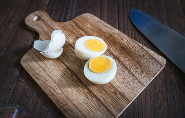 boiled egg peeled and cut in half on a cutting board. 