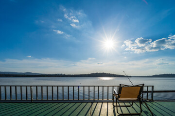 Fototapeta na wymiar River atmosphere, clear sky, fishing chair and fishing rod.