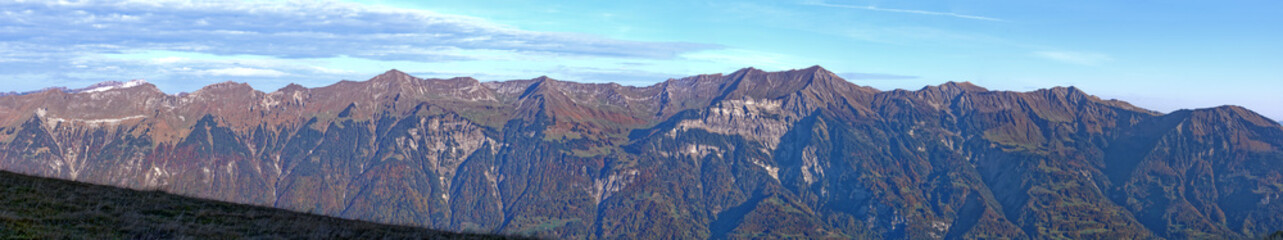 Beautiful wide angle autumn landscape at Bernese Oberland with Bernese Alps, Lake Brienz and mount Brienzer Rothorn on a blue cloudy autumn morning. Photo taken October 18th, 2022, Axalp, Switzerland.