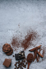 Chocolate powder, beans, chocolate bars and chocolate food on gray background with copy space. 