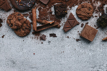 Various chocolate stuff on gray background with copy space. 