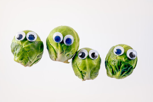 Group Of Brussel Sprouts With Funny Googly Eyes Isolated On A White Background