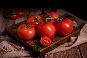 Red tomatoes lie on the table in the kitchen 
