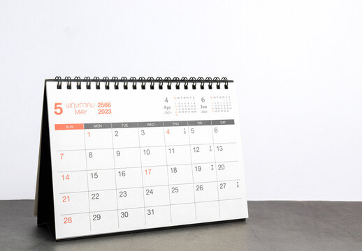 month May 2023 desk calendar for planners and reminders on a black table on a white background.
