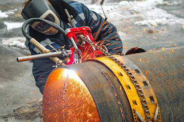 Working welder cuts metal and sparks fly. Gas cutting of large diameter pipes with acetylene and...