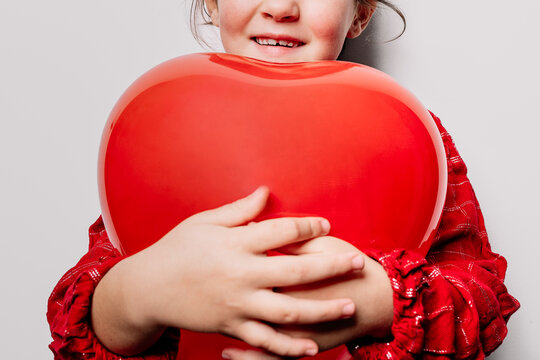 Anonymous delight girl hugging heart shaped balloon