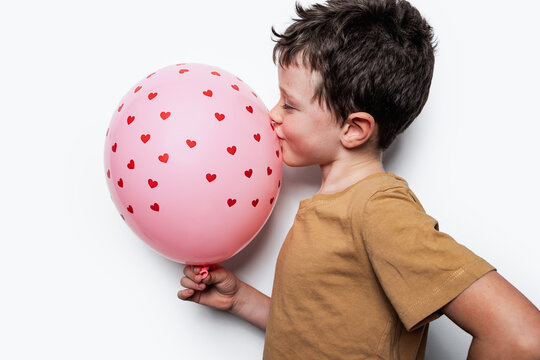 Boy kissing balloon with hearts