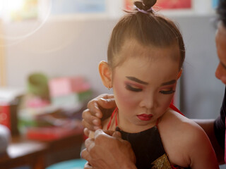 young traditional dancer prepare backstage before the performance at the school.