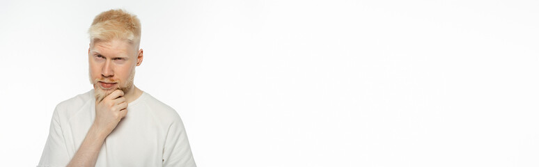 pensive albino man touching beard while thinking on white background, banner